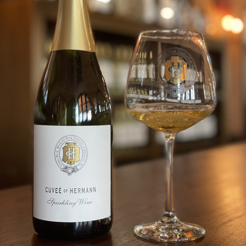 Bottle and glass of G Husmann cuvee sparkling on a bar
